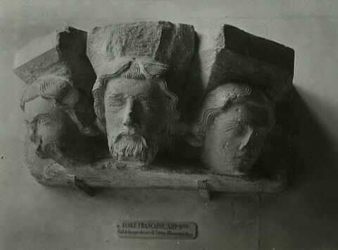 Culot décoré de trois têtes d'hommes