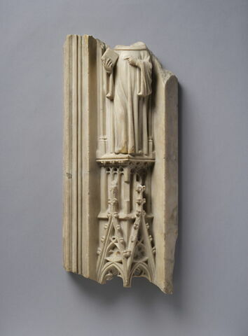 Pinacle surmonté d'une figure mutilée d'ecclésiastique tenant un livre