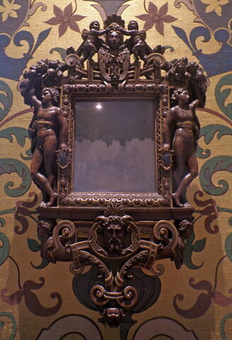 Miroir en glace métallique, dans un cadre en bois sculpté et doré