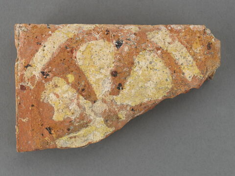 Fragment de carreau de pavage : fleur stylisée à cinq pétales, un pétale manque