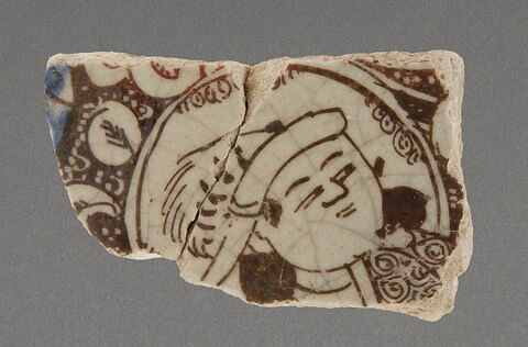 fragment de carreau au personnage coiffé de plumes de hiboux