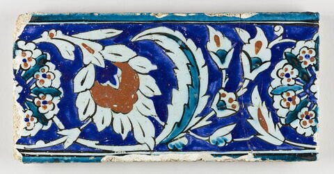 Carreau de bordure au rinceau fleuri à palmette feuillue et rosettes fleuries sur fond bleu