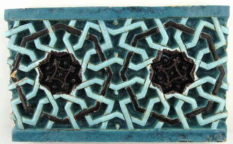 Fragment de carreau de revêtement à décor d'étoiles à huit branches et d'octogones, image 1/3