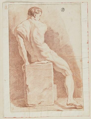 Un jeune homme assis sur un bloc de pierre, vu de dos