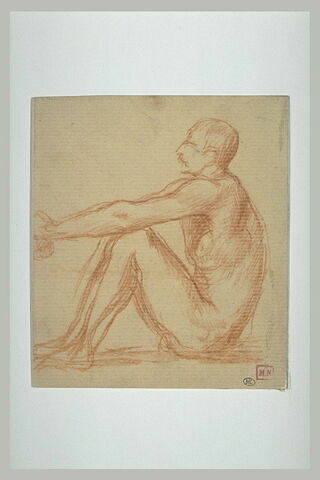 Homme nu, assis à terre, les genoux relevés, de profil à gauche