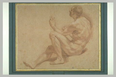 Homme assis de profil, une jambe étendue le genoux ployé, tenant un objet, image 3/3