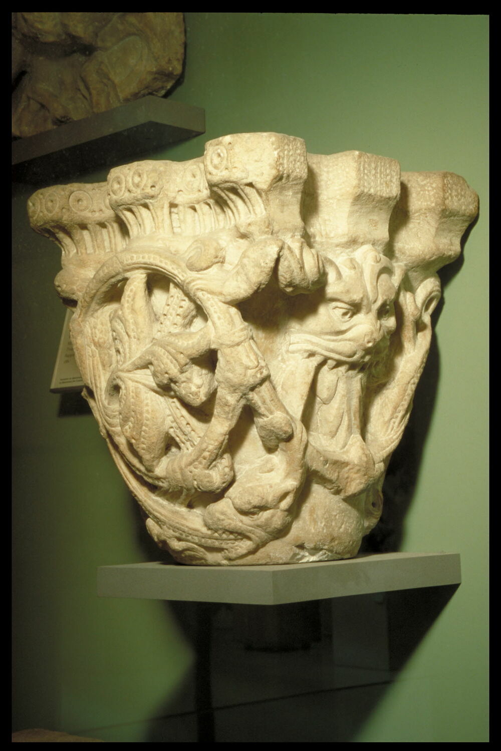 Chapiteau décoré de rinceaux perlés, de feuillages et d'une tête de ...