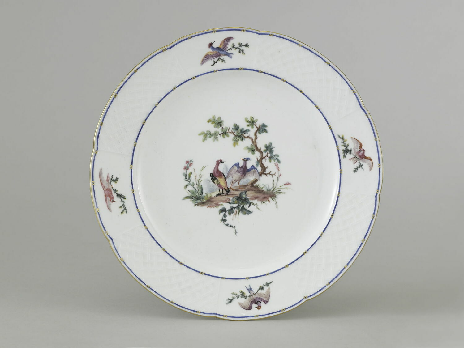Assiette au marli blanc, à décor d'oiseaux polychromes