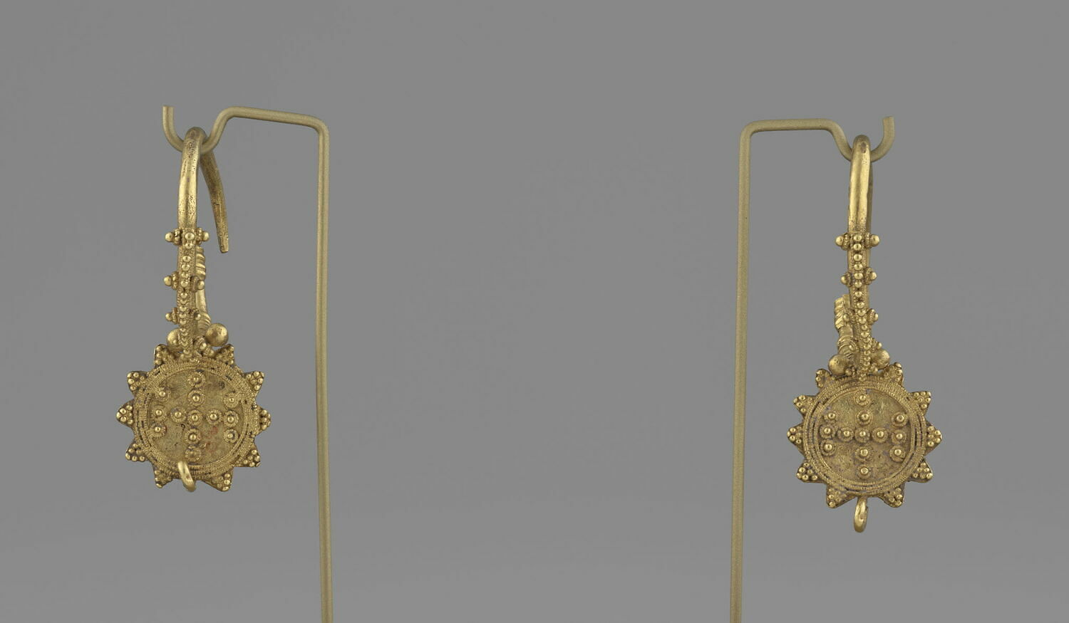 Paire de boucles d'oreille avec deux T opposés sur la demi-sphère