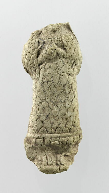 Molded statuette of a woman wearing a scaled coat