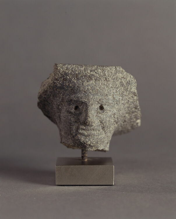 Fragement of a mortar decorated with a human face. Acropolis of Ras Shamra.