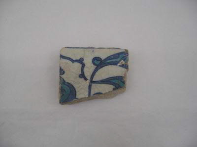 Fragment de carreau aux feuilles bifides et fleurons turquoises meublés de rumis bleu cobalt