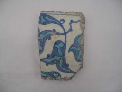 Fragment de carreau aux feuilles bifides et fleurons turquoise meublés de rumis bleu cobalt