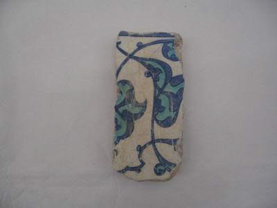 Fragment de carreau aux feuilles bifides et fleurons turquoise meublés de rumis bleu cobalt