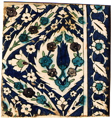 Carreau de bordure à composition florale losangée sur fond bleu sombre. Bordure à rinceau de rosettes sur fond bleu sombre