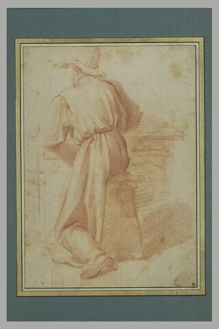 Homme vêtu d'une longue robe, coiffé d'un chapeau, assis à une table, vu de dos, image 3/3