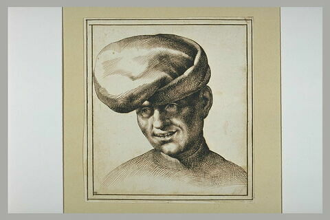 Une tête d'homme coiffé d'un bonnet, souriant, image 2/2