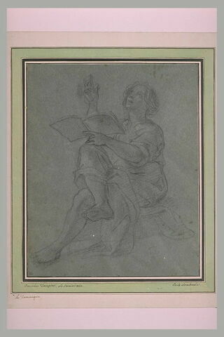 Jeune homme assis, jambes croisées, tenant un livre, les yeux levés, image 2/2