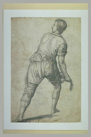 Homme debout, de dos, se retournant, et tirant sur quelque chose, image 1/1