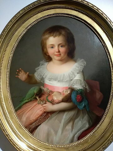 Portrait d'une petite fille jouant avec sa poupée et avec une petite perruche