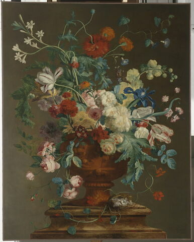 Grand Vase orné de putti et rempli de fleurs de différentes espèces, posé sur un piédestal de marbre