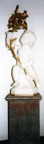 Enfant assis portant une branche de lys de sa main gauche