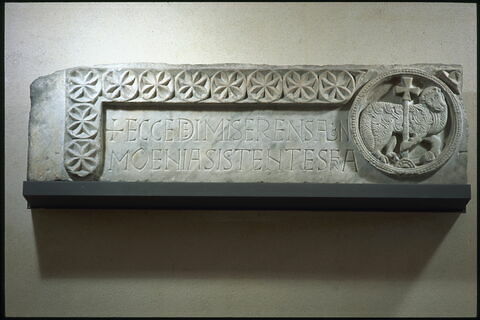 Partie gauche d’un linteau décoré de l’Agneau divin (autrefois au centre) et portant une inscription