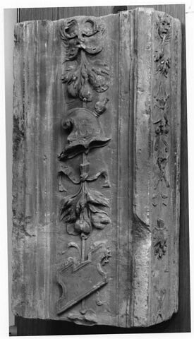 Fragment de pilastre : décor de masque feuillu tenant un bouquet de fruits, un casque et un cartouche, image 1/1