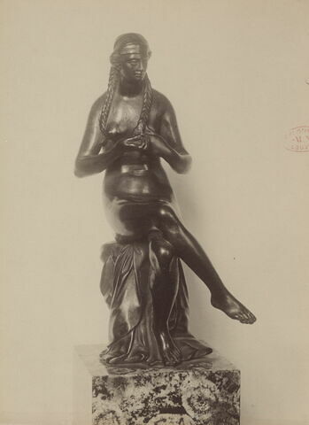 Statuette : femme se tressant les cheveux