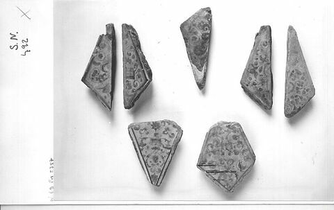 Sept carreaux triangulaires et fragments de carreaux losangés
