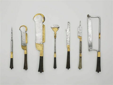 Trousse de piqueur comprenant 7 instruments :  passe-corde, petit couteau à défaire, couteau à défaire, hachette articulée de veneur, couteau, lime à carrelette, scie à main