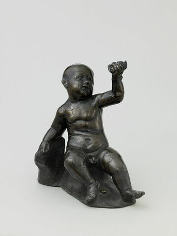 Statuette : un gros enfant nu assis, tenant une coquille de la main gauche