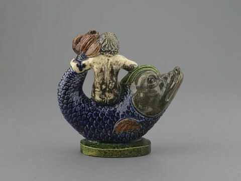 Vase à verser en forme de statuette : enfant nu chevauchant en amazone un dauphin, image 1/1
