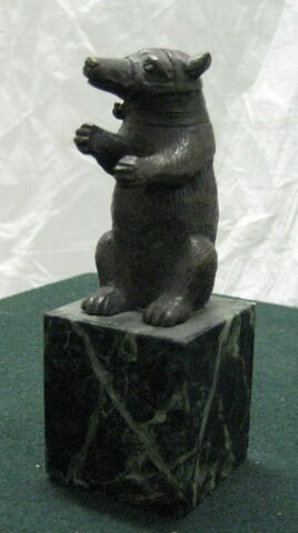 statuette : ours assis portant une muselière