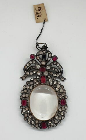 Médaillon pendentif de forme ovale, en cristal de roche, dans un cadre en strass de rubis surmonté d'un noeud semblable, image 1/2