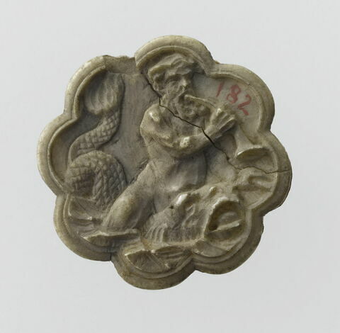 Médaillon polylobé : Triton jouant de la trompe à cheval sur un dauphin.