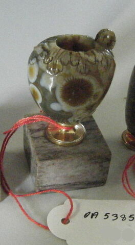 Vase à panse ovoïde, à deux anses prises dans la masse et orné de gravures représentant des feuillages et un soleil