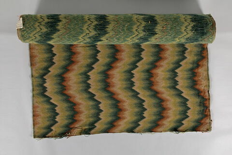 Tissu de laine imitant la tapisserie décoré, sur fond beige, d'ornements en dents de scie verts et ocre. 
Dimensions : H.: 1, 40 ; L.: 5, 25 ?