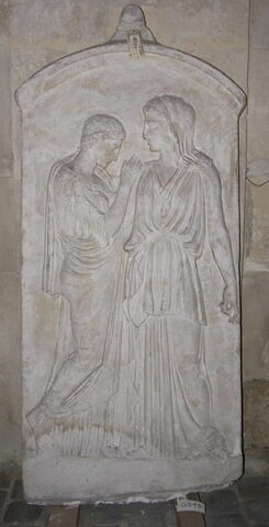 Tirage d’une stèle funéraire
Lamère est vêtue d'un chiton, d'un péplos, et d'un voile ; la fille porte un chiton et un himation. 
Une inscription en grec donne le noms des personnages <Kritô Timarista>.