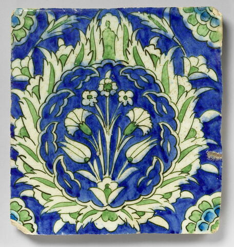 Carreau à la grosse palmette feuillue enfermant une touffe de fleurs sur fond bleu, image 1/1
