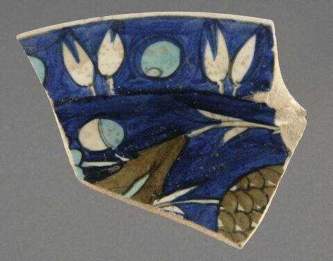 Fragment de plat à aile droite : sur fond bleu feuille hanceri et fruit à écaille, image 1/1
