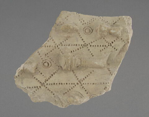 Tesson à décor de colonne en relief, têtes à bonnet 