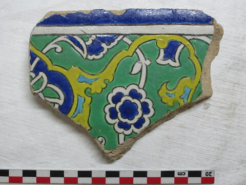 Fragment d'un carreau de bordure au rinceau de rumi enfermant des fleurettes et des pivoines