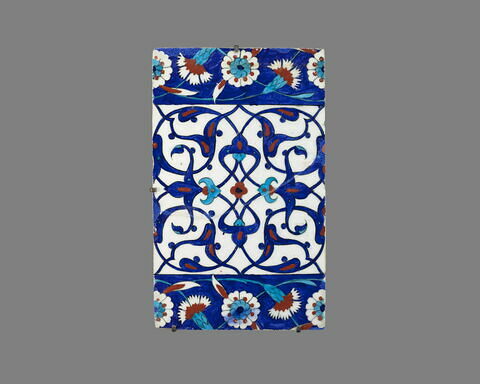 Carreau de bordure aux quadrilobes faits de fleurons bifides rumi et frises de rosettes et d'oeillets sur fond bleu