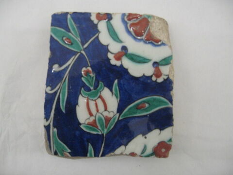 Fragment de carreau de bordure au rinceau de feuilles hançeri, palmettes et fleurs composites sur fond cobalt