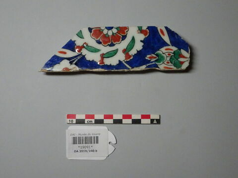 Fragment de bordure à fleurs-palmettes et feuilles fleuries sur fond bleu