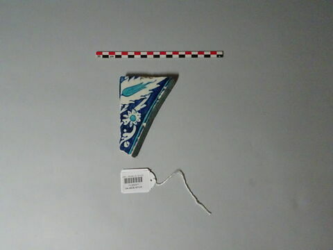 Carreau d'un tympan aux fleurons bifides rumi monumentaux sur fond turquoise. Bordure d'oeillets et de feuilles dentelées sur fond bleu : départ d'arc, image 1/1
