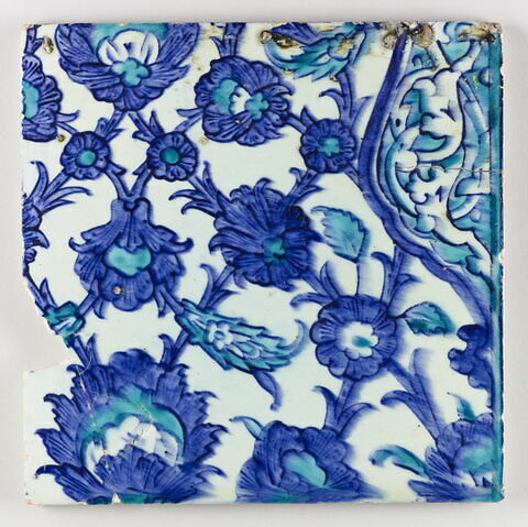 Carreau d'un panneau à niche fleurie et bordure de rinceaux fleuris sur fond bleu