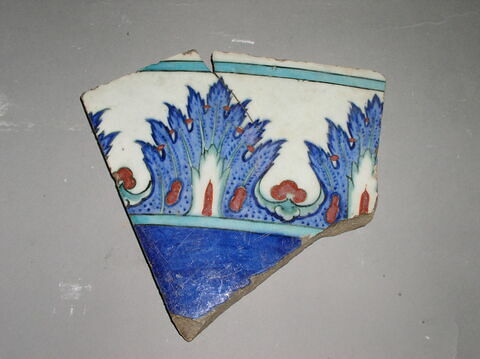 Fragment de carreau à bordure de fleurons alternés cernant une inscription à fond bleu, image 1/1