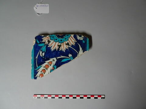 Fragment de carreau de bordure à frise de rosettes et de feuilles hanceri fleuries sur fond bleu, image 1/1